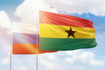 Sunny blue sky and flags of ghana and russia