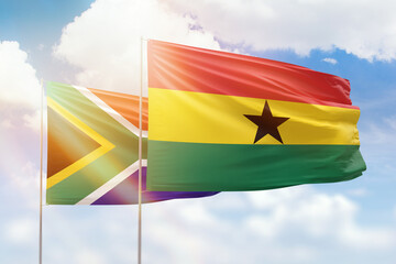 Sunny blue sky and flags of ghana and south africa