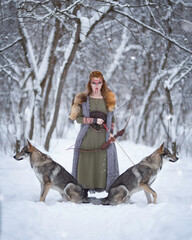 Viking girl with a bow in her hands and two wolves