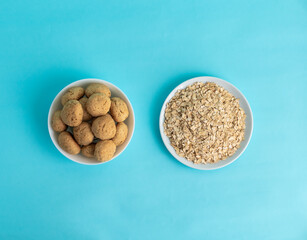 Flatlay oatmeal, oatmeal cookies on a white plate on a blue background, top view, the concept of healthy eating and making cereal or cookies. High-quality photo