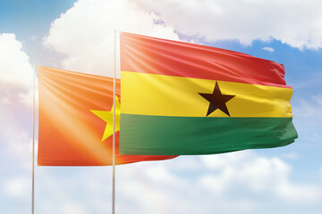 Sunny blue sky and flags of ghana and vietnam