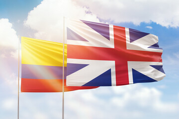 Sunny blue sky and flags of great britain and colombia