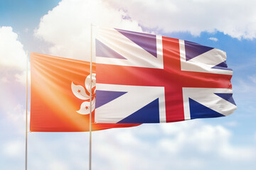 Sunny blue sky and flags of great britain and hong kong