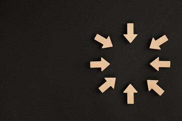 Wooden arrows point on black background. Space for your text