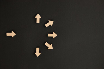 Wooden arrows point on black background. Space for your text