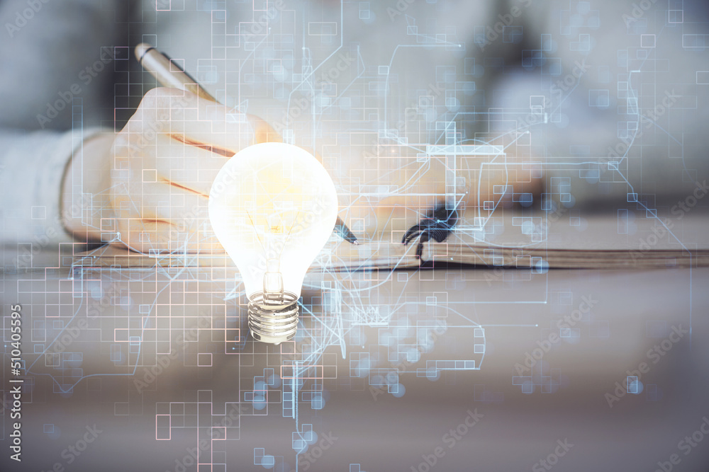 Aufkleber bulb hologram over hands taking notes background. concept of idea. double exposure