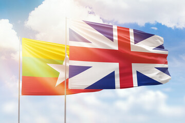 Sunny blue sky and flags of great britain and myanmar