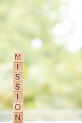 The word Mission on wooden cubes They lie on other cubes against the backdrop of the summer garden