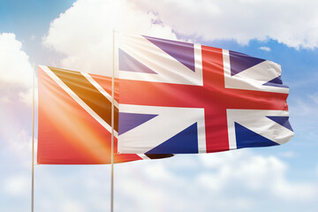 Sunny blue sky and flags of great britain and trinidad and tobago