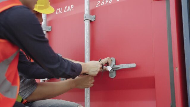 Male worker uses a white plastic seal to lock the lid of a container, and a female auditor uses a wireless barcode reader to record the security seal. Logistics, Import, Export, Shipping yard concept.