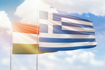 Sunny blue sky and flags of greece and hungary