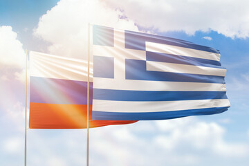 Sunny blue sky and flags of greece and russia