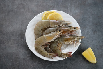 Fresh shrimps served on plate on dark background. Selective focus image.
