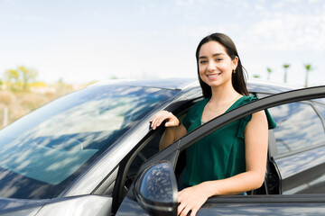 Happy young woman with a new car