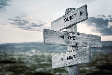 quiet the mind text quote caption on wooden signpost outdoors in nature. Stock sign words theme.