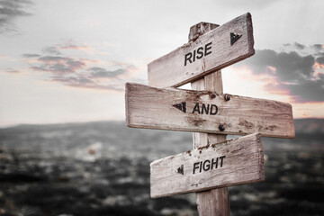rise and fight text quote caption on wooden signpost outdoors in nature. Stock sign words theme.
