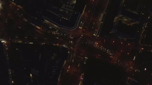 Birds eye shot of cars passing through street intersection in night city. Crossroads of wide multilane streets. Cologne, Germany