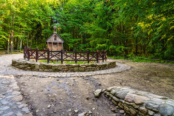 Traditional forest shrine and spring of St. Francis in Swieta Katarzyna village near Bodzentyn at tourist path to Lysica peak in Swietokrzyskie Mountains in Poland - obrazy, fototapety, plakaty