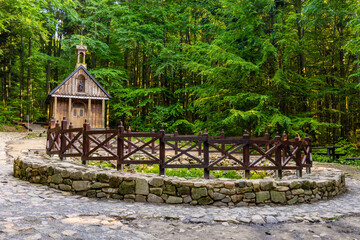 Traditional forest shrine and spring of St. Francis in Swieta Katarzyna village near Bodzentyn at tourist path to Lysica peak in Swietokrzyskie Mountains in Poland - obrazy, fototapety, plakaty