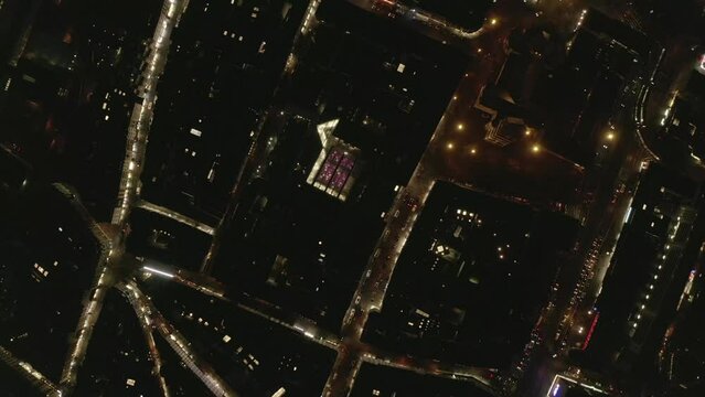 Birds eye footage of evening in city. Cars driving on illuminated streets between buildings in urban borough. Cologne, Germany