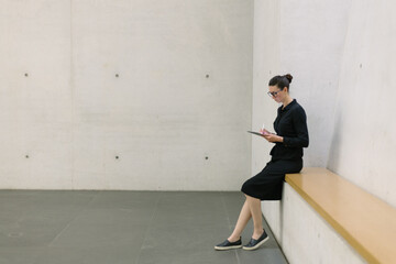 Fototapeta na wymiar Business woman using tablet pc in minimalist office interior