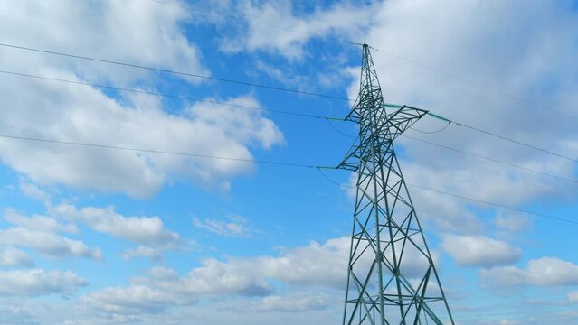 Electricity, high voltage power line pylon at day, silhouette and blue sky. Time lapse.