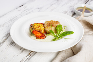 Delicious and healthy homemade food. Turkey cutlets and grilled vegetables. Cheese sauce with garlic and olive oil. Food composition on white wooden background. Close-up. Copy space