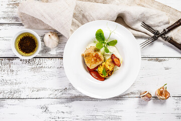 Delicious and healthy food. Homemade turkey cutlets and grilled vegetables. Cheese sauce with garlic and olive oil. Food composition on white wooden background. Top view. Copy space