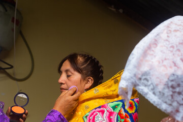 Latin woman dressed in a typical costume of the Peruvian Andes, being made up.