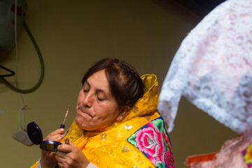 Latin woman dressed in a typical costume of the Peruvian Andes, being made up.