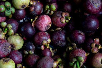 Above view of mangosteen fruit stacked together for sale. Background and textured of natural fruit of Thailand.