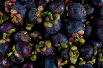 Above view of mangosteen fruit stacked together for sale. Background and textured of natural fruit of Thailand.