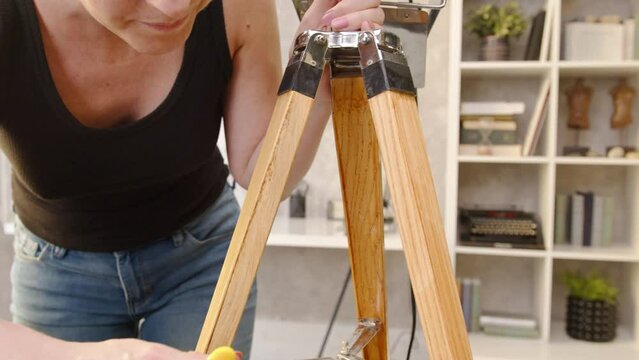 DIY - Do It Yourself. Young woman renovating and painting a design lamp at home. Renewing, tinkering, home improvement.