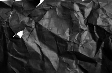 Black paper with white tears for the background. Crumpled paper texture with messy tears. 