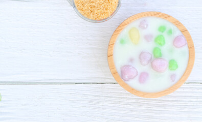 Thai dessert with colorful flour, milk, egg, rainbow colored tapioca Famous Thai dessert, Bualoy on a wooden table, top view.