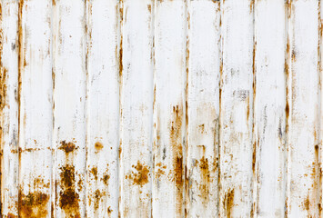 Weiß lackierte Wand aus Blech mit dunklen Rostflecken als Hintergrund