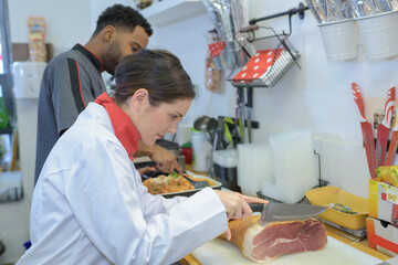 female butcher cutting meat