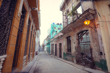 Street scene with classic old cars and traditional colorful buildings in downtown Havana.