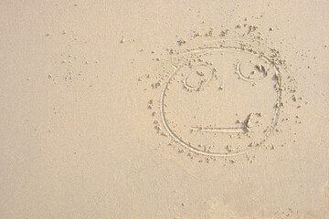 Top view on face drawing on a sand.