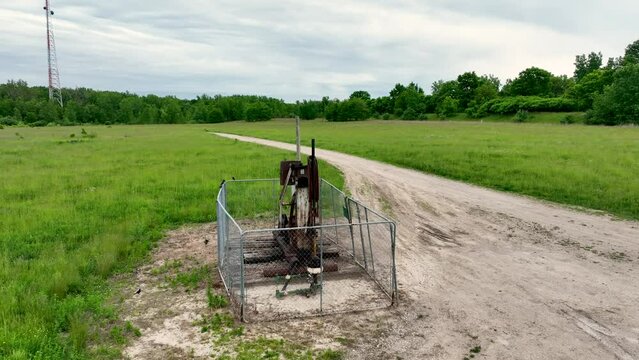 Old Rusty Oil/natural gas well pumping in Michigan near Grand Rapids