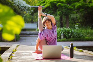 An old slender woman does yoga in the park online