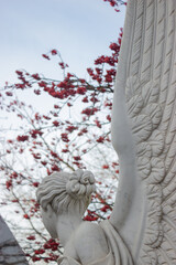 White marble sculpture against the sky and rowan branches with red berries