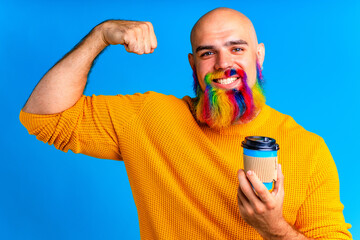 cool mature man holding cup of coffee in blue wall background in studio