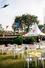 Festa Junina decoration on farm. Hats, balloon, chairs and landscape with lots of green.