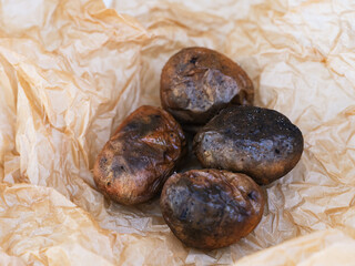 Four baked potatoes on a parchment