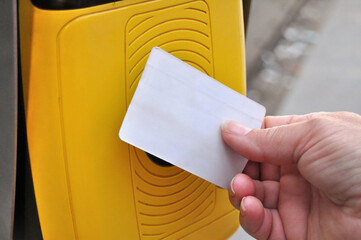 Mão de uma pessoa a validar um cartão numa maquina de validação, cartão em branco sem...