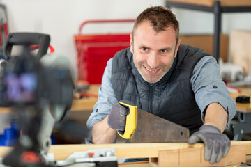 male worker in hand sawing wood