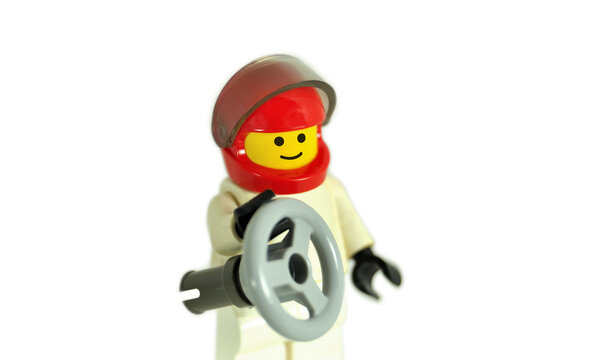 Piloto de desporto automóvel com volante na mão, boneco de lego