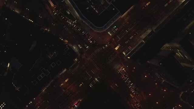 Aerial view of night city. Top down ascending and rotating footage of traffic on intersection in urban borough. Cologne, Germany
