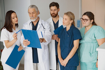 Doctor giving lecture to interns in hospital discussing patient diagnosis